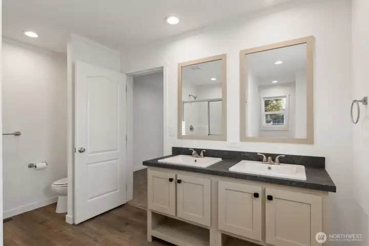 The private bathroom off the primary room has a double sink vanity.