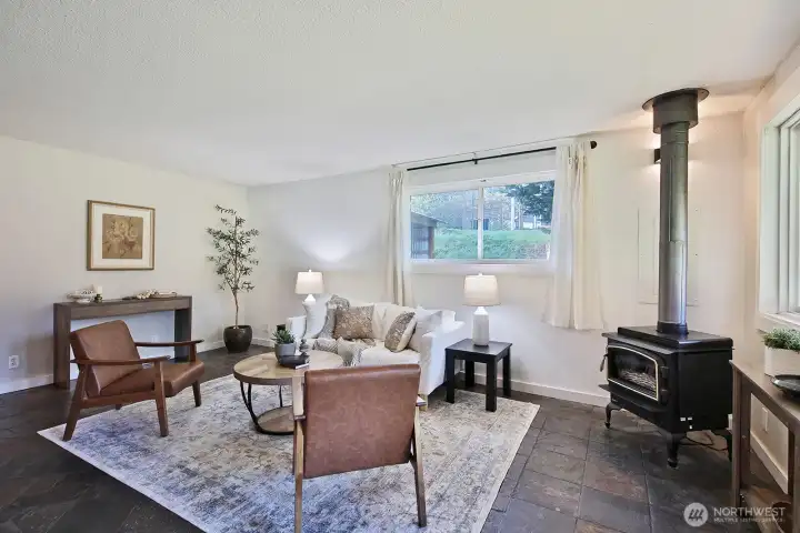 The living room (upon entry) with the kitchen to your back. Cozy propane stove and ceramic tiled floors.