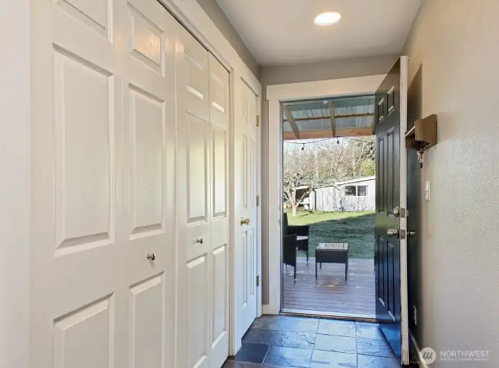Hallway that leads from the living room to the covered side deck. Washer & Dryer are in the first closet along the left side of this photo.