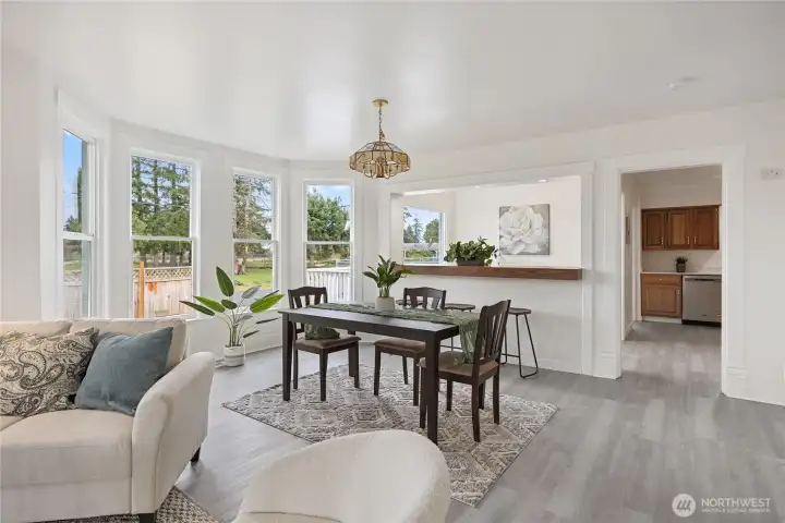 Bright and cheery living space is lined with windows letting sunshine in.