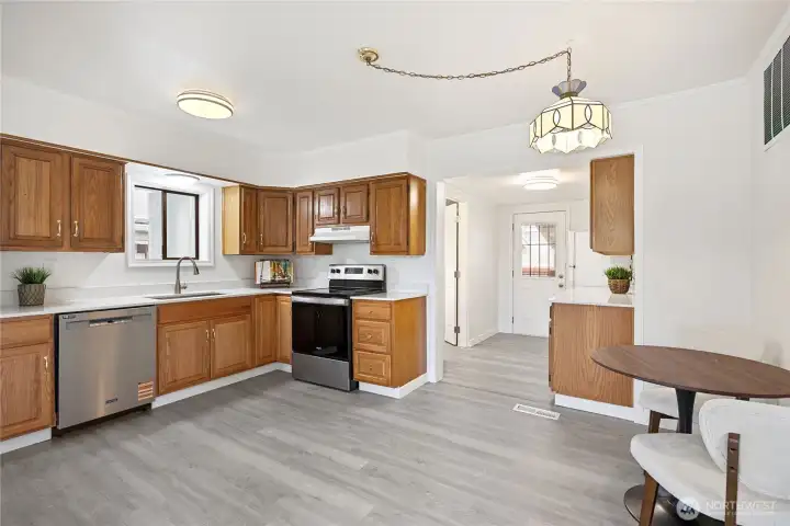 The large open kitchen has abundant cabinet and counter space, new quartz counter tops, new dishwasher and lower cabinets.