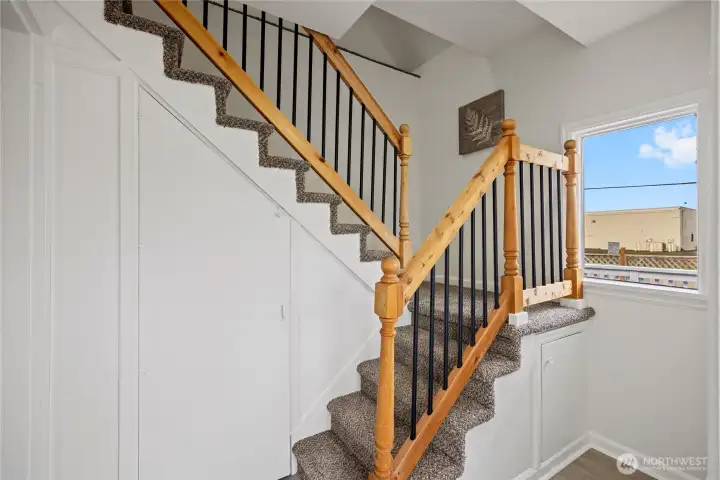 New stair railing and carpet leads to upstairs.