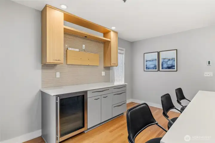 Breakfast nook enhanced by a TV-framed shelf and convenient beverage cooler.