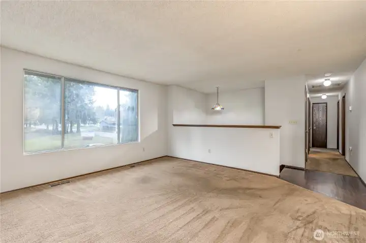 Living room has large bright window overlooking the front of the property
