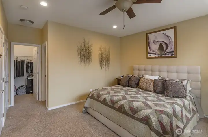 Spacious primary suite is large enough for the largest of furniture.  Hallway leads to a walk-in closet and bath.