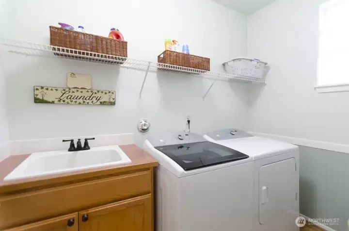 Utility room with deep sink, storage cabinet and a window.  Notice the wainscotting detail in this room.