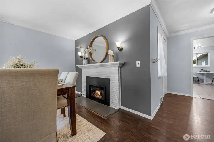 Warmth and style meet in the heart of the home! This bright dining area boasts a cozy gas fireplace, an eye-catching accent wall.