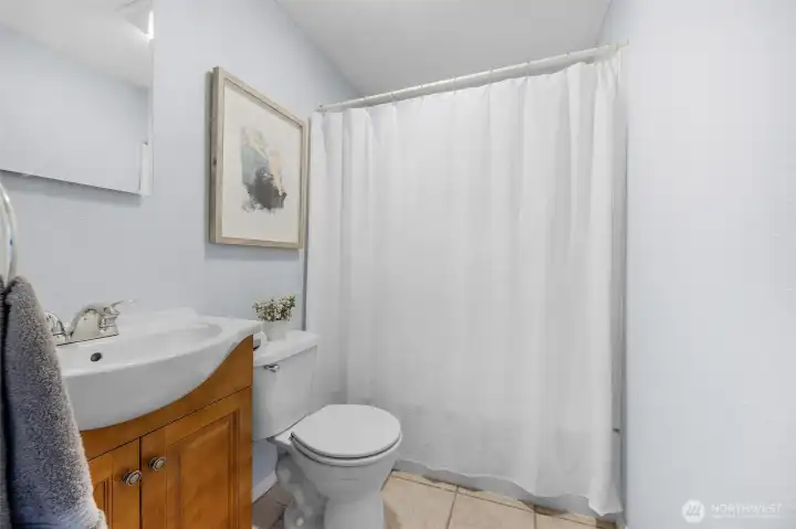 Well-appointed second-floor full bathroom highlights a classic wood vanity, durable tile flooring, and a tub/shower combo. Perfectly situated to serve the upstairs bedrooms!