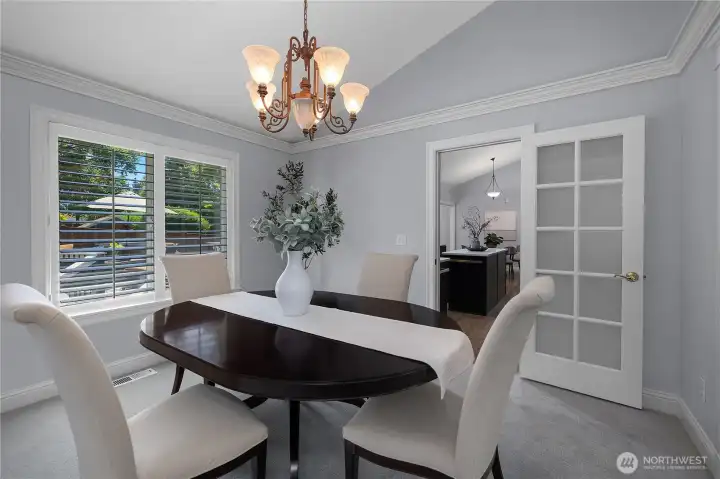 A lovely view of the backyard is framed through the large picture window and access to the kitchen is through the glass door. A lovely view of the backyard is framed through the large picture window and access to the kitchen is through the glass door.