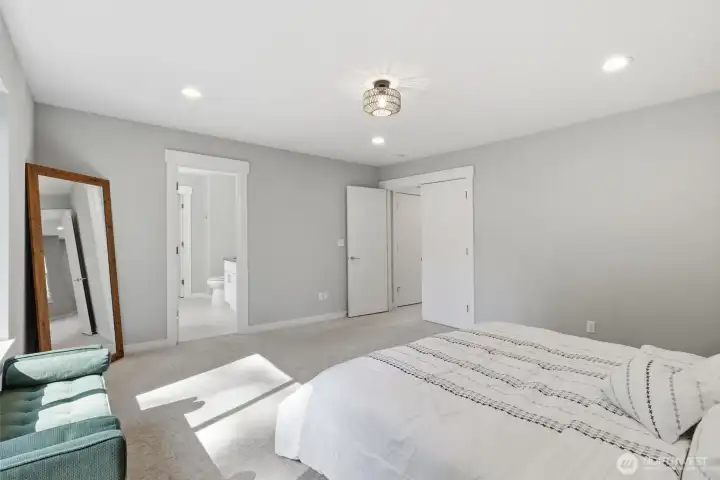 A calm + spacious bedroom with soft light and room to unwind.