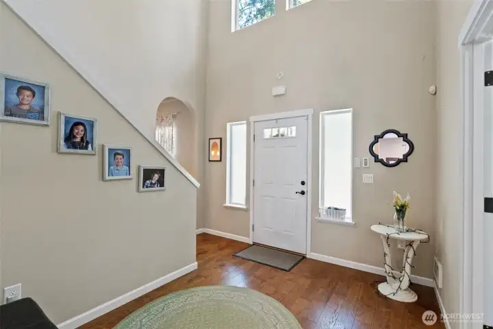Entryway with 20 foot ceiling, arched doorway and lots of natural light.