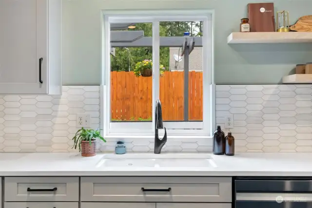 Picket marbled tile backsplash and open shelving give this space a classic modern feel.