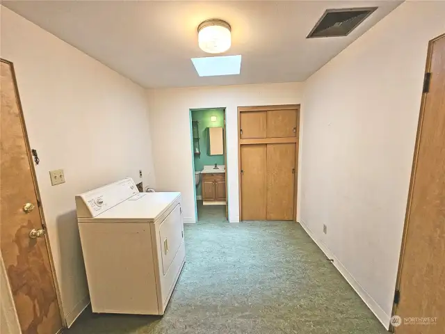 Large mud room has doors to garage and back yard.