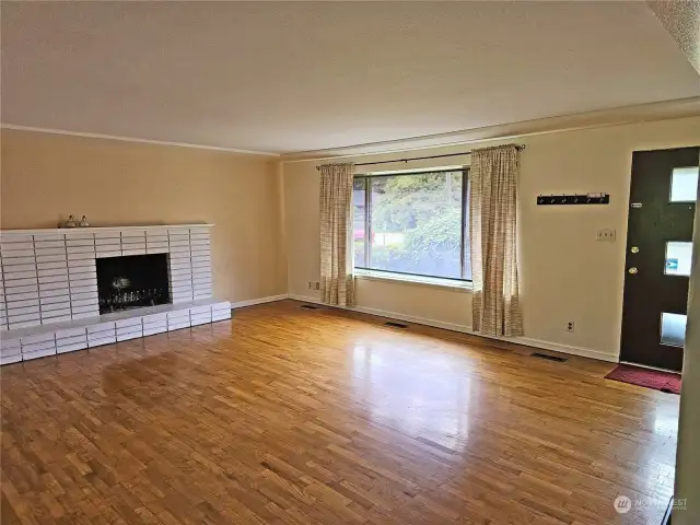Enter into the spacious living area with  hardwood floors and fireplace.