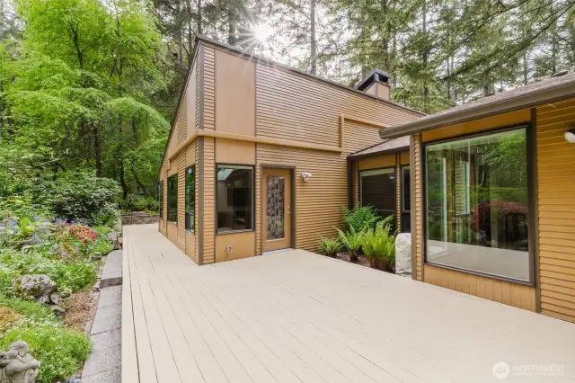 The expansive patio wraps around the rear of the home, offering multiple entrances that seamlessly connect the indoor and outdoor spaces...