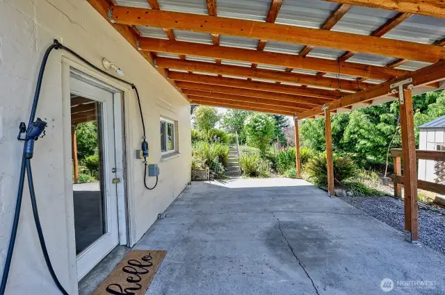 Carport with access to downstairs and EV charger.