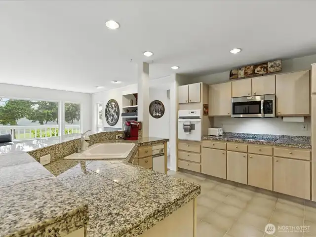 A beautiful light and spacious kitchen with views of golf course and large pond as you enjoy this large kitchen island.