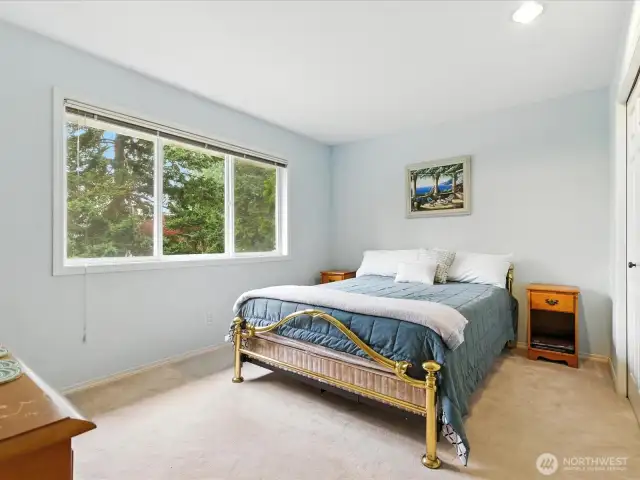 Bedroom upstairs with a view of trees.