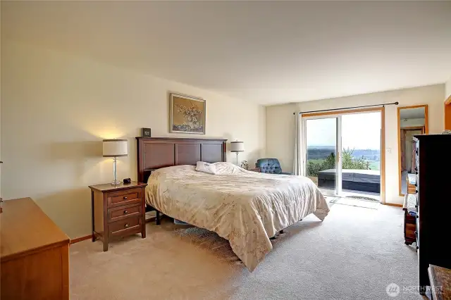 Large primary bedroom with huge walk-in closet, ensuite, and slider onto the large deck with hot tub!