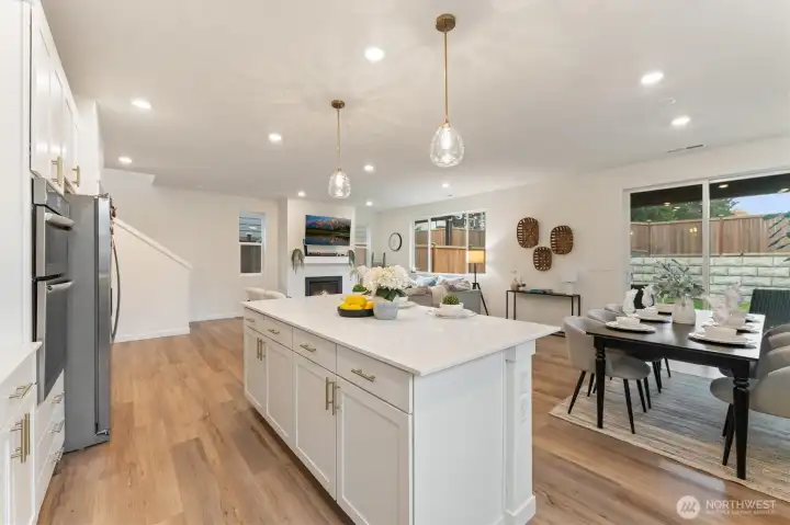 Chef-inspired kitchen with oversized island, quartz countertops, stainless appliances, and ample cabinetry.
