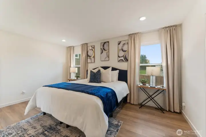 Primary bedroom retreat with large windows, and a calming neutral palette.