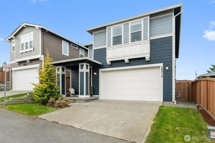 Full exterior front view with driveway, attached garage, and contemporary design.