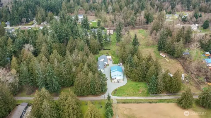 Aerial view to the north, showcasing the two homes (duplex) with 40 X 60 shop on 5 acres. Great opportunity!