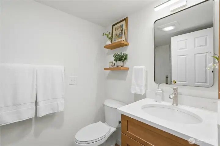Beautifully updated three-quarter bath blends a serene, natural aesthetic with a walk-in shower, stunning tile details, and elevated finishes that make the most of the space.