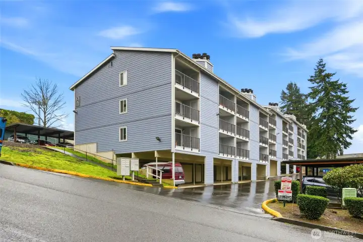 The rear of the building features an assigned covered parking space and a convenient private storage unit.