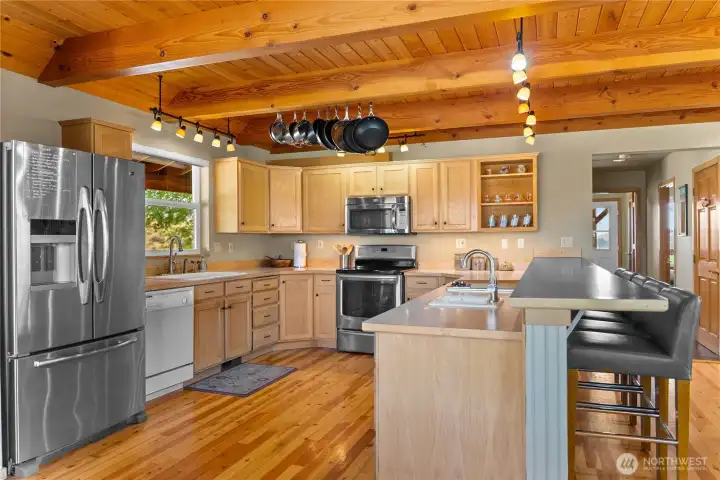 Stainless steel appliances complimented with the glow of wood floors and ceiling create a welcoming, nurturing energy.  Perfect for a kitchen!