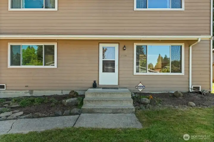 Front door with fresh landscaping.