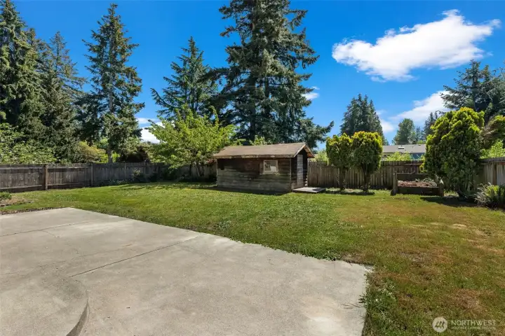 Fenced backyard with a handy storage shed.