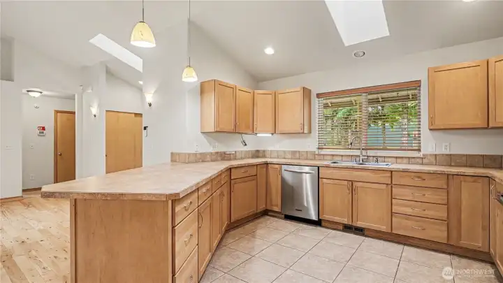 Oversized window above the sink frames views of the front yard while bringing in natural light.