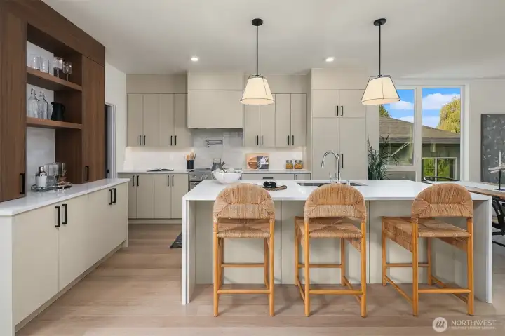 Two-tone cabinetry and waterfall quartz counters. Integrated appliances and spacious island. Two-tone cabinetry and waterfall quartz counters. Integrated appliances and spacious island.