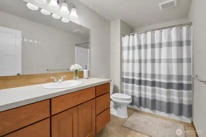 Main level full bath serves guests and the 2 bedrooms on this level. Virtually staged. Main level full bath serves guests and the 2 bedrooms on this level. Virtually staged.