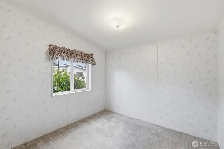 Guest bedroom at SW corner of the home has walk in closet. Natural lighting from the vinyl window facing the street area.