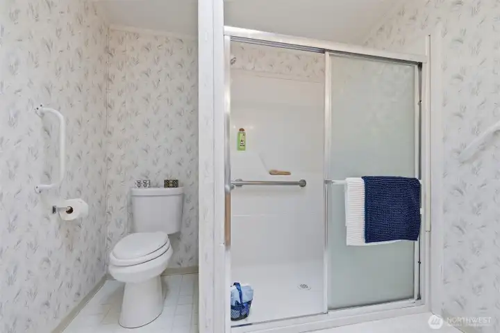 Step in shower with grab bars for your convenience. High rise style commode in private area of the bathroom.
