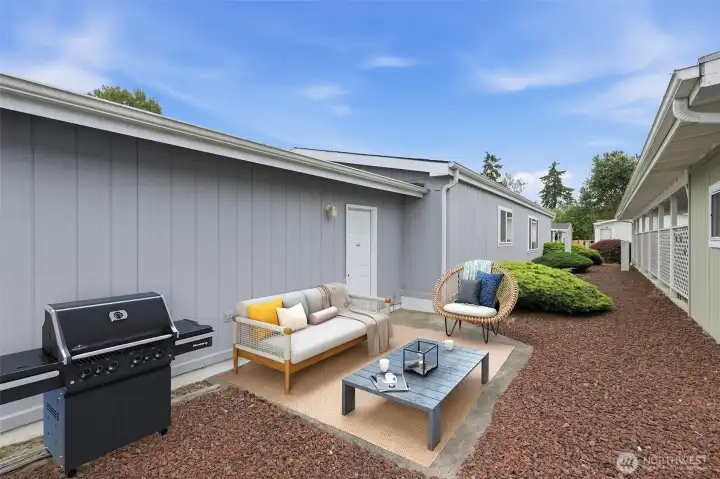 Back yard patio area off the garage. Private area is great place for barbeques or just sit outside and enjoy the quiet of your community. Virtually stagged.