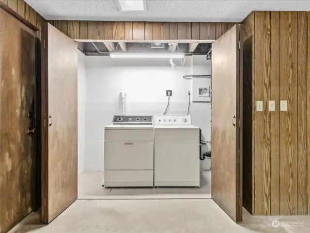 Full side-by-side washer and dryer are located in basement utility closet