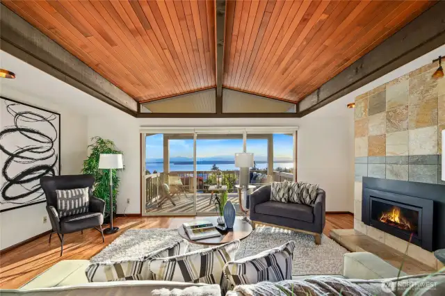 The living room with vaulted wood ceilings, gas fireplace and sliding doors to a covered deck.
