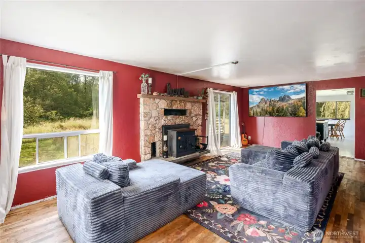 Front entry family room with natural hardwoo flooring, woodstove fireplace