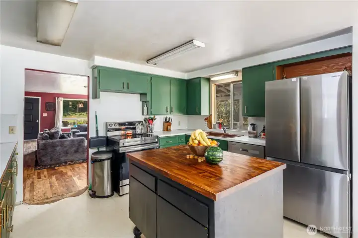Kitchen in the main home with newer appliances and applicance. Additional cabinetry and cupboards off to the side of the photo