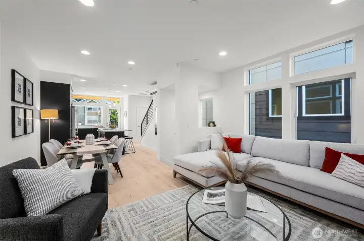 This open-concept great room is designed for modern living, seamlessly connecting the living area, dining space, and kitchen. Ideal for hosting friends or family, its thoughtful layout encourages connection and conversation. Photos of home with similar layout, finishes & fixtures.