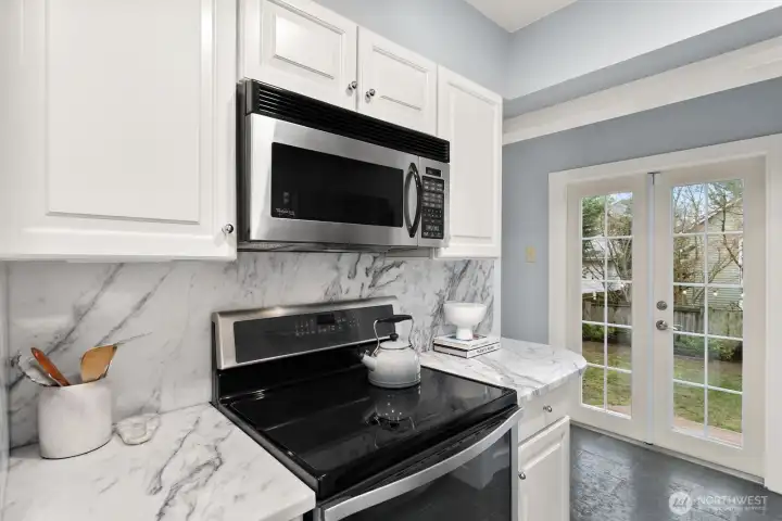 French doors off of kitchen open to deck and fenced, level back yard!