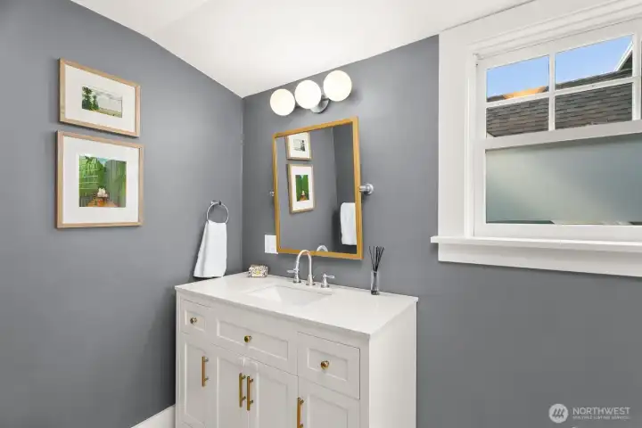 Sunny upper level full bath sports newer vanity able to house all of your personal necessities.