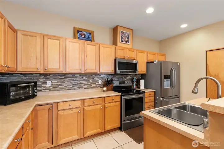 Chef-inspired Kitchen with abundant cabinetry, tile floor, and pantry.