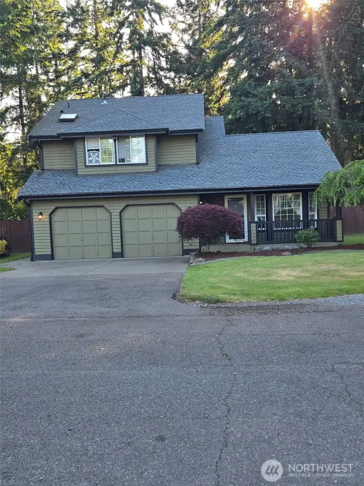 Welcome home to 25608 68th Ave E—this striking front exterior shot showcases the home’s curb appeal with a lush green lawn, long driveway, and charming covered porch. Surrounded by serene trees and natural privacy, this property blends country comfort with Northwest style. Ideal for buyers seeking peace, space, and practicality.