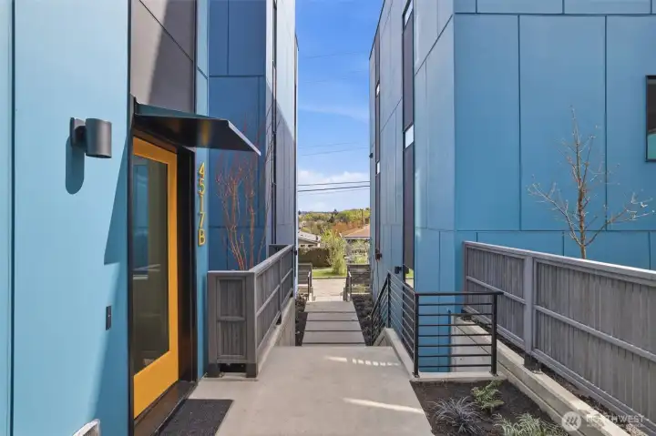 Welcoming private entrance with landscaped walkway, fenced outdoor space, and stylish modern exterior design. Welcoming private entrance with landscaped walkway, fenced outdoor space, and stylish modern exterior design.