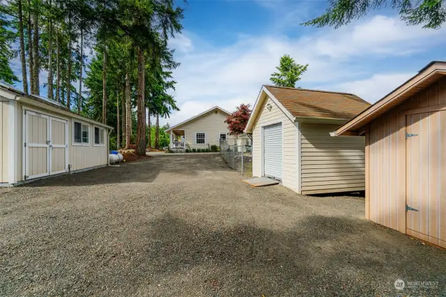 Huge circular driveway with RV, boat parking. Tuff shed with power and 2 extra outbuildings for yard equipment or whatever you choose to use them for