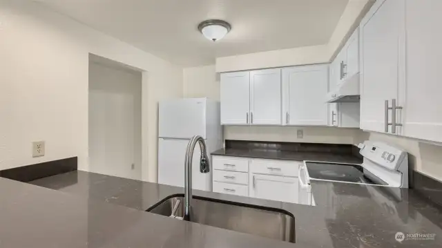 White shaker cabinetry, sleek countertops, undermount sink & all appliances stay.